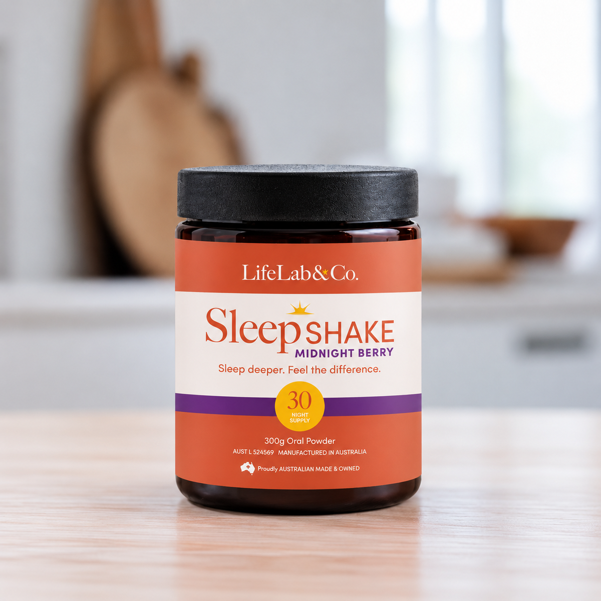 A jar of LifeLab & Co. Sleepshake Midnight Berry oral powder sits on a light wooden table with a softly blurred kitchen background.